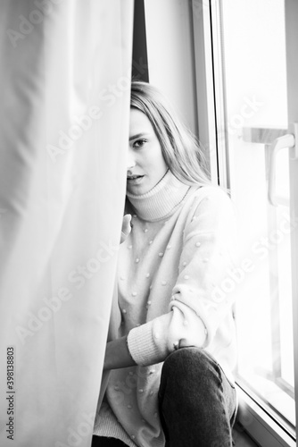 Young beautiful woman in warm knitted handmade clothes at home. 