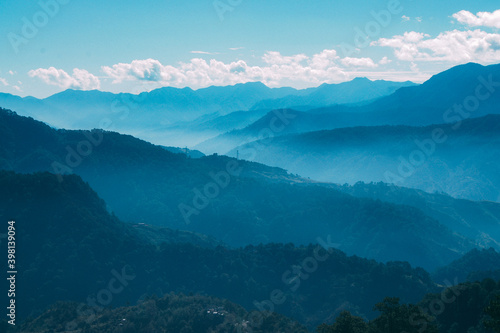 a landscape with trees and mountains in the background © kingmauri