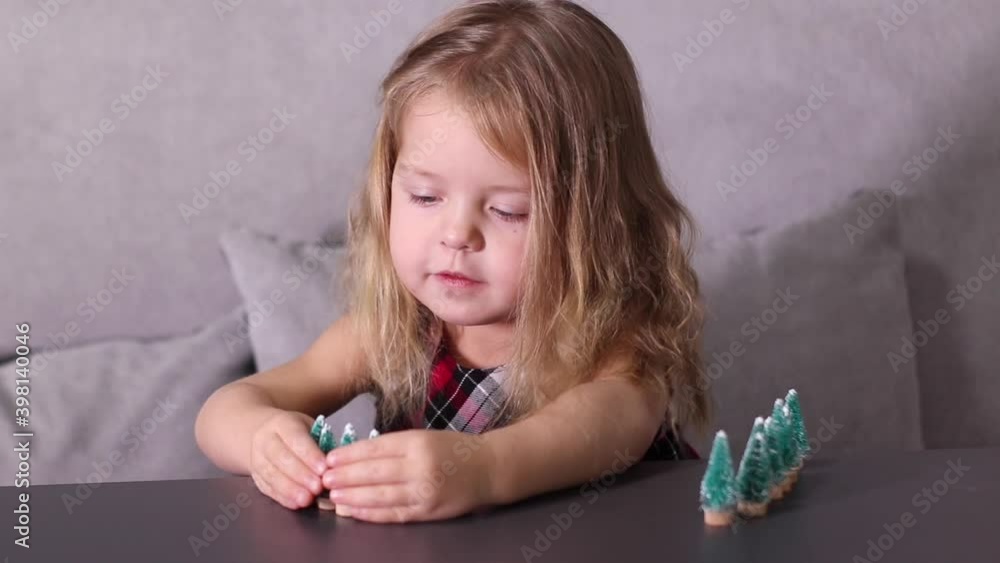  pretty little girl playing with little christmas trees toys, decorations. new year, childhood, daughter. FullHD footage