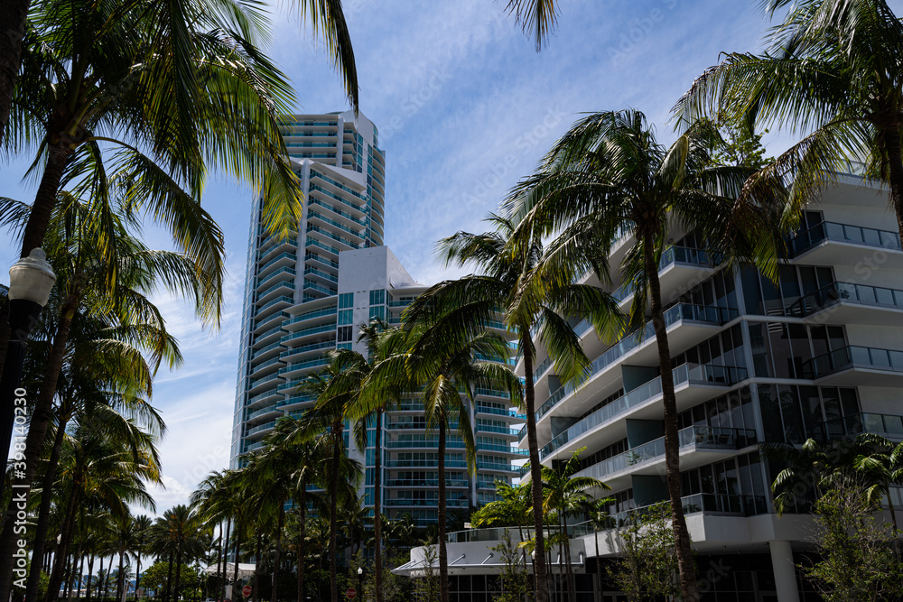 Miami Beach, Florida, USA - May, 2020: Skyscraper at Miami Beach. Street in Miami with palms.