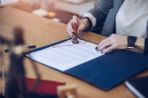 A woman notary, a lawyer stamps the seal on the notarial act.
