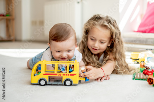 Canvas Print Brother and sister playing together, girl spending time with sibling, teaching h