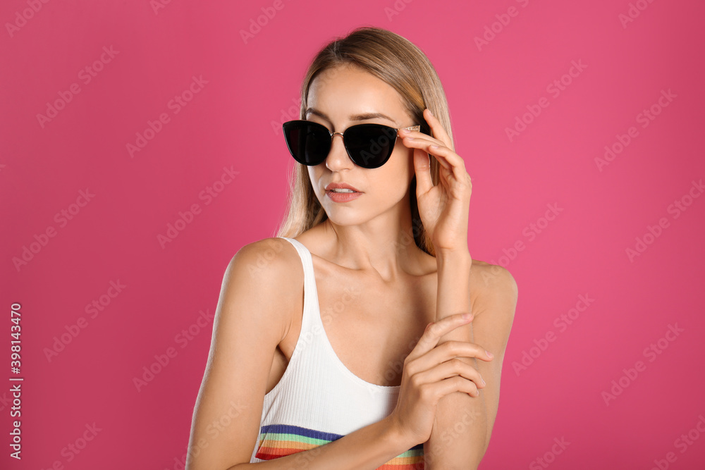 Naklejka premium Beautiful woman in stylish sunglasses on pink background