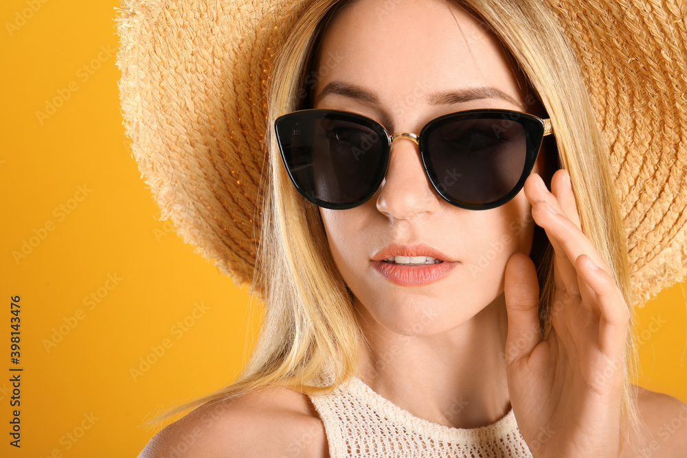 Beautiful woman in stylish sunglasses on yellow background, closeup