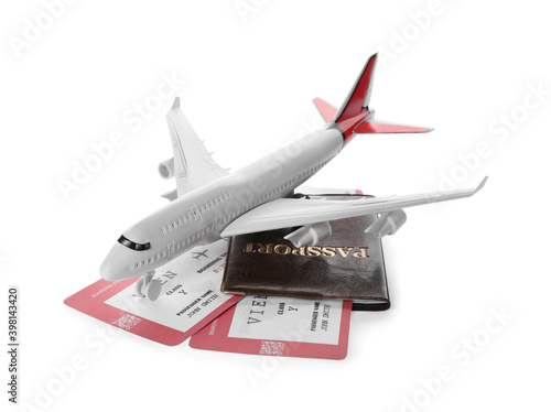 Toy airplane and passport with tickets on white background