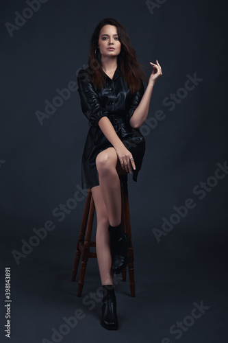 Young brunette girl poses in style clothes