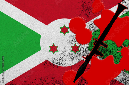 Burundi flag and black RPG-7 rocket-propelled grenade launcher in red blood. Concept for terror attack or military operations with lethal outcome photo