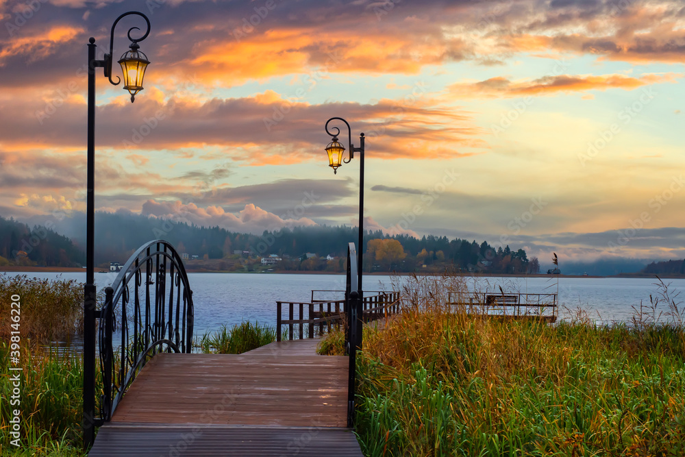 Nature of Karelia. Sunset over Lake Ladoga. Landscape of Russia. Wooden bridge leads to lake. Bridge in vintage style near Lake Ladoga. Road to pier in Karelia. Travel in the Russian Federation