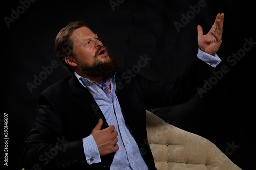 Solid bearded man in suit singing opera studio portrait