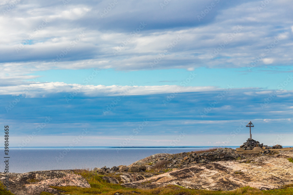 Beautiful arctic summer landscape on Barents sea shoreline with christian cross.