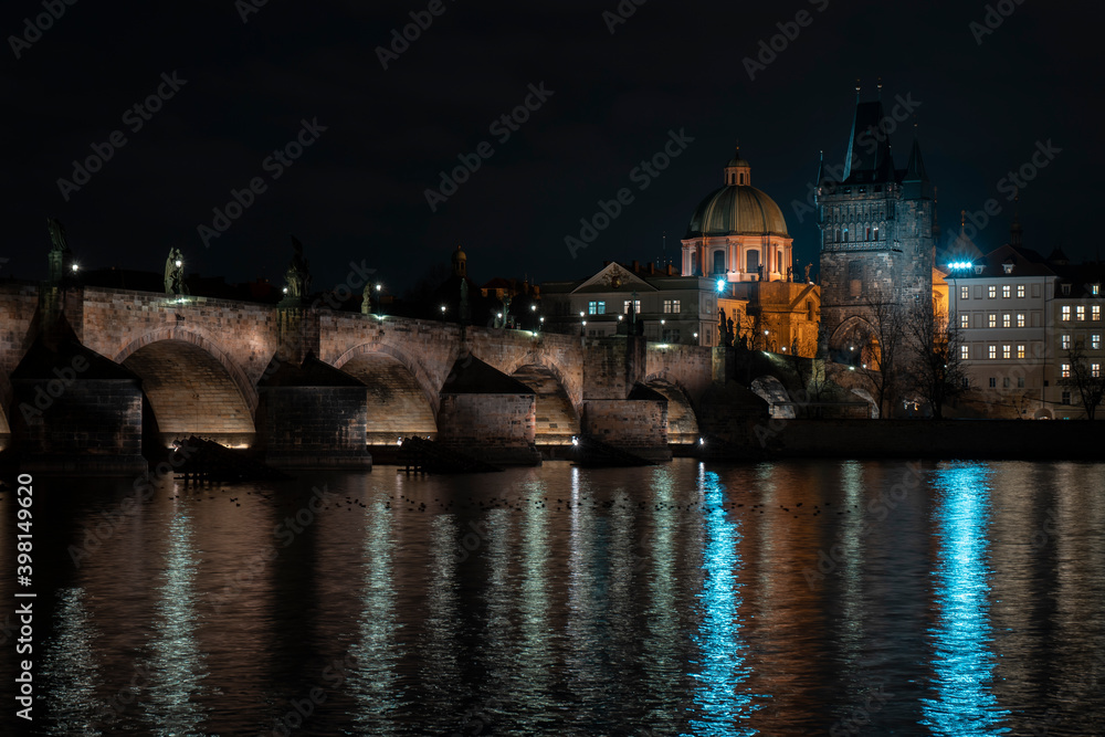 Fototapeta premium .Charles Bridge and lights from street lights are reflected on the surface of the Vltava River in the center of Prague at night in the Czech Republic