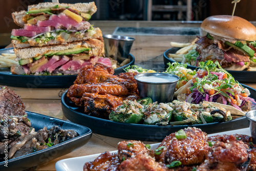 Εκτύπωση καμβά Full table of delicious meals straight from the grill including appetizer plate of tacos and stacked ahi tuna club sandwich