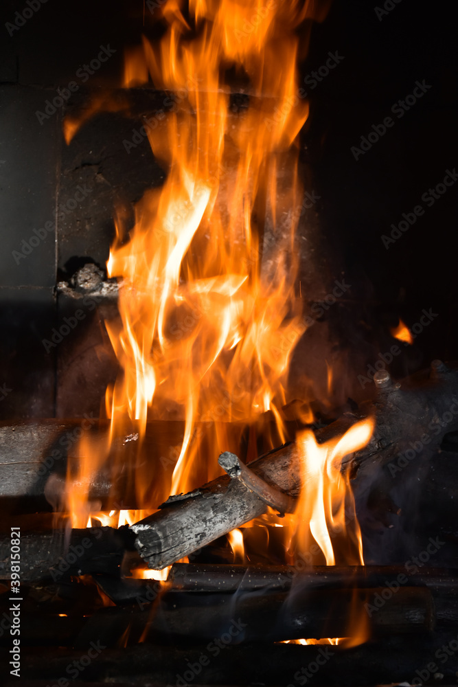Fire flames in fireplace. Burning wood in fireplace in a countryside house. Close up. Warming and relaxing near fireplace in cold autumn (fall) or winter days. Fire flames in fireplace. Burning wood in fireplace in a countryside house. Close up. Warming and relaxing near fireplace in cold autumn (fall) or winter days.