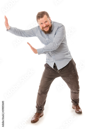 Joyful bearded man in shirt pushing invisible wall