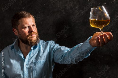 Solid bearded man in shirt with glass of whisky