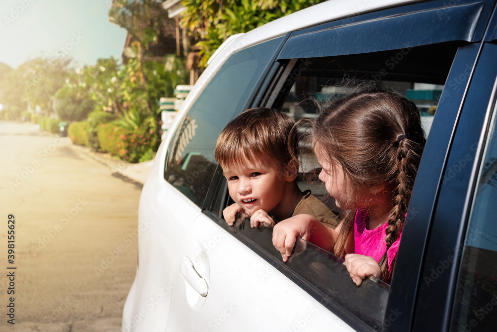 children lean out of the car window