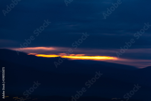 Last sunset rays among dark blue clouds over a mountain landscape city near Plovdiv  Bulgaria