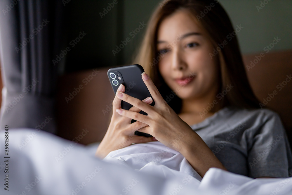 Beautiful long hair women play smartphone on the bed after wake up in the morning. Beautiful long hair women play smartphone on the bed after wake up in the morning.