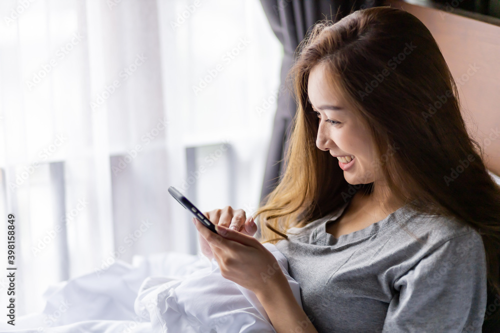 Beautiful long hair women play smartphone on the bed after wake up in the morning. Beautiful long hair women play smartphone on the bed after wake up in the morning.
