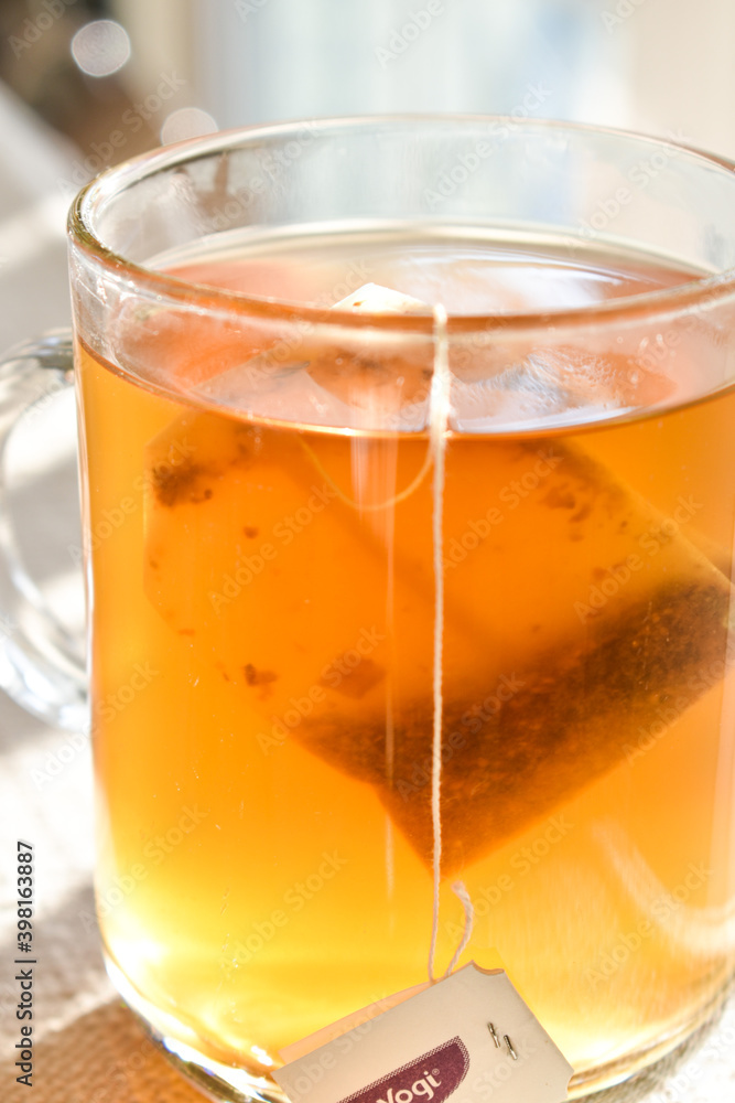 A beautiful glass filled with golden tea in the afternoon sunlight. A beautiful glass filled with golden tea in the afternoon sunlight.