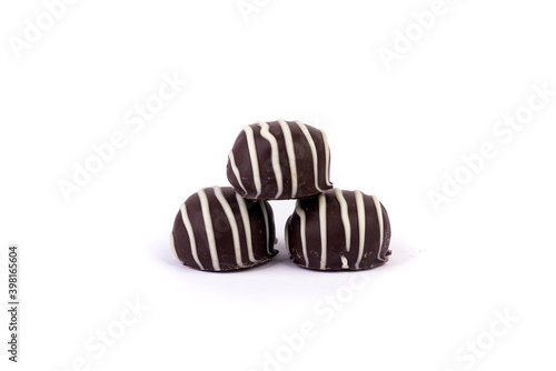 Three molded filled striped chocolates stacked in a pyramid isolated over white
