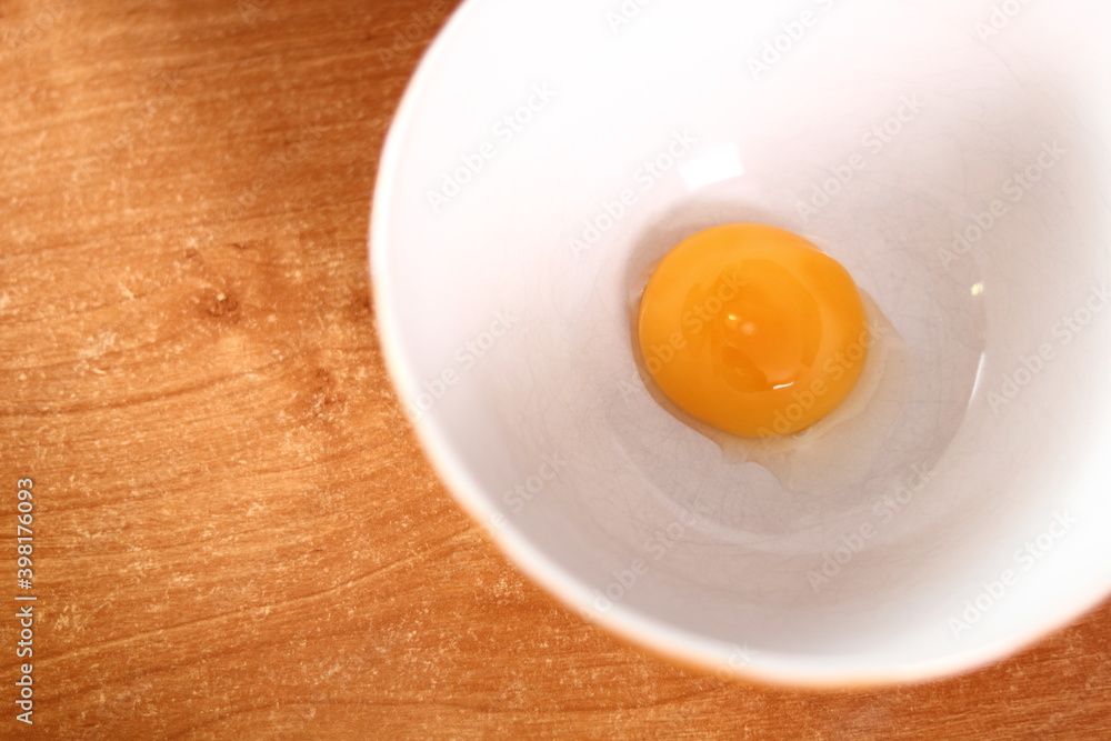 Separating egg yolk from white. Making mayonnaise with a wooden spoon. Separating egg yolk from white. Making mayonnaise with a wooden spoon.