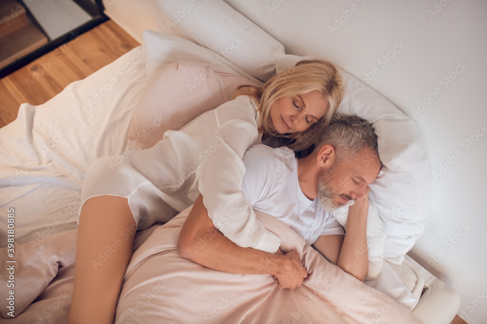 Married couple resting on a bed at home Married couple resting on a bed at home