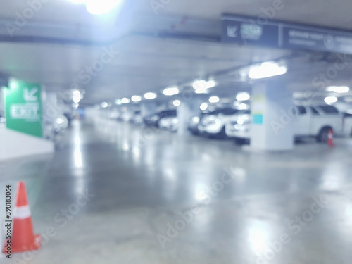 Abstract blurred cars parked in parking lot of shopping mall. Defocused background