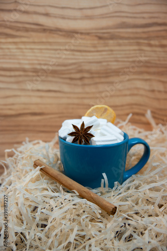 White marshmallow in a green mug with star anise and cinnamon, glare from sparkles, romantic blur.
