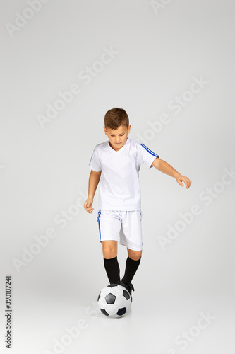 little child boy playing with soccer ball over studio background. © producer