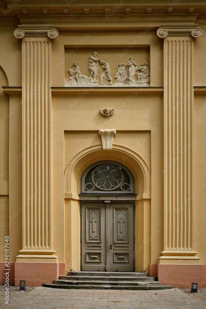 Hauptportal mit ionischen Pilastern an der klassizistischen Neuruppiner Stadtpfarrkirche St. Marien - das Relief zeigt 