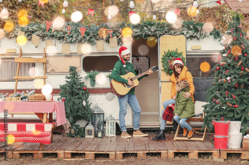 Happy family with guitar outdoors on Christmas eve © Pixel-Shot