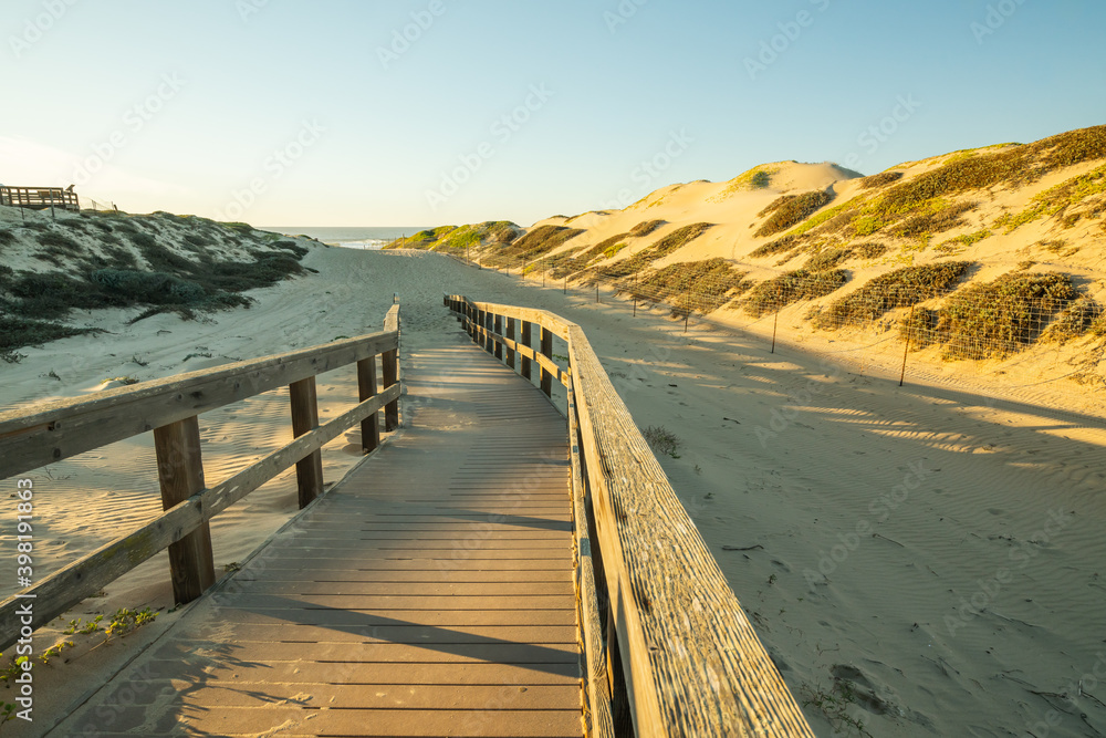 Rustic wooden beach boardwalk through sand dunes, Oso Flaco Lake Natural Area State Park, California