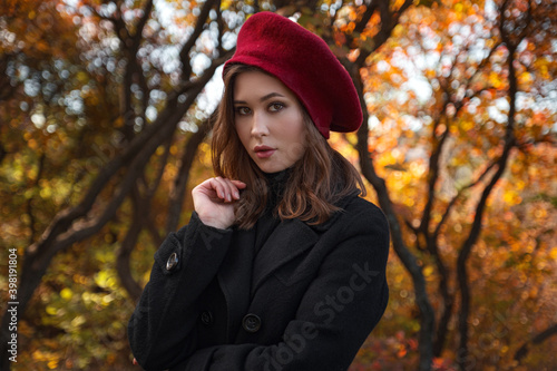 Beautiful young woman walking in the autumn forest