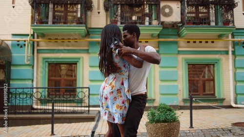 Young couple rotating hips on street. Dancers perfoming dance together at city. photo