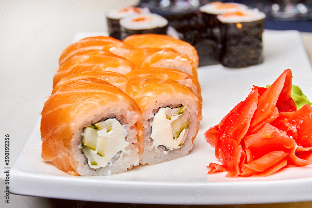 Rolls with salmon and cucumber, cheese and wasabi on a white plate. Closeup, selective focus