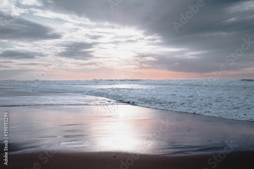 Peaceful tranquil scene  beautiful sunset on the beach in light pink and blue colors