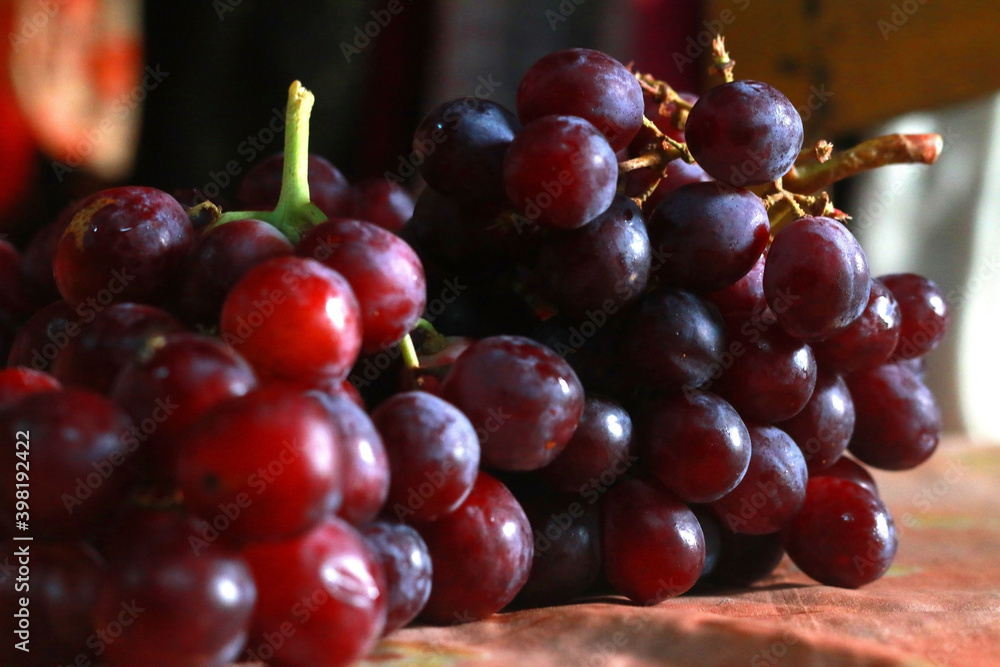 Fototapeta premium Healthy fruits Red wine grapes background/ dark grapes/ blue grapes/wine grapes,Red wine grapes background/dark grapes,blue grapes,Red Grape in a supermarket local market bunch of grapes ready to eat