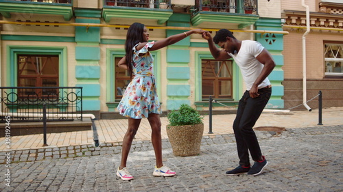Fotografie African couple dancing jive in city