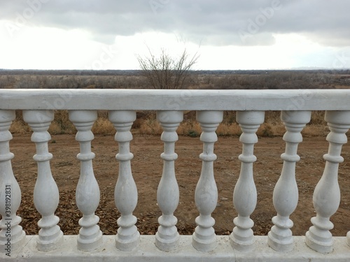 Volzhsky, Volgograd region, Russia – November 26, 2020: snow-white decorative elements of balusters in the form of columns against the background of an autumn-winter landscape, sky