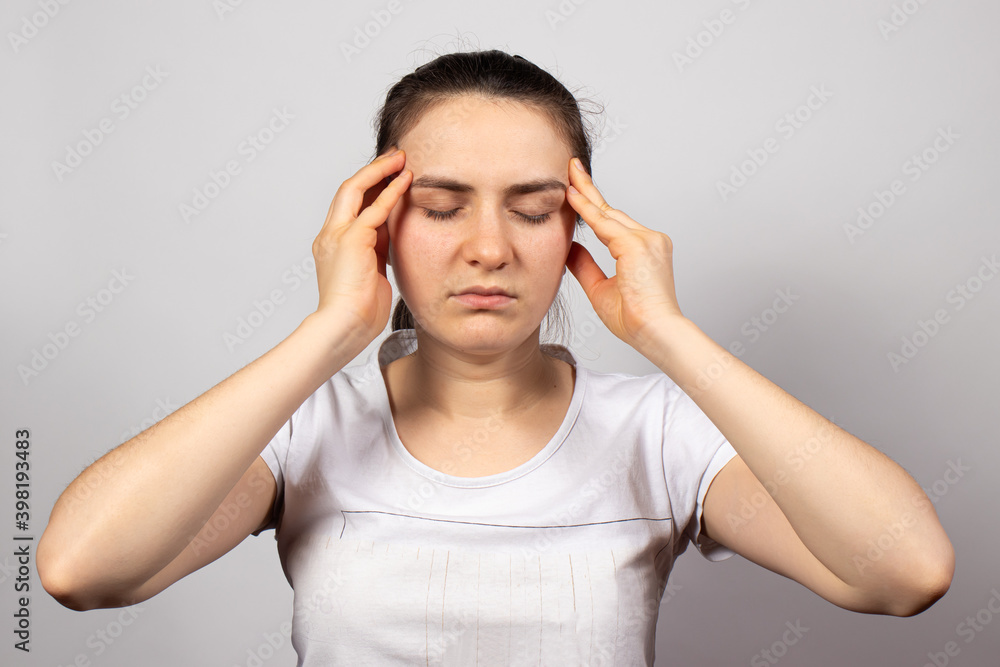 A beautiful girl in a white T-shirt holds her hands by the temple, concentrating during meditation. Disclosure of chakras in yoga. Self-knowledge and introspection, a woman thinks and solves problems A beautiful girl in a white T-shirt holds her hands by the temple, concentrating during meditation. Disclosure of chakras in yoga. Self-knowledge and introspection, a woman thinks and solves problems