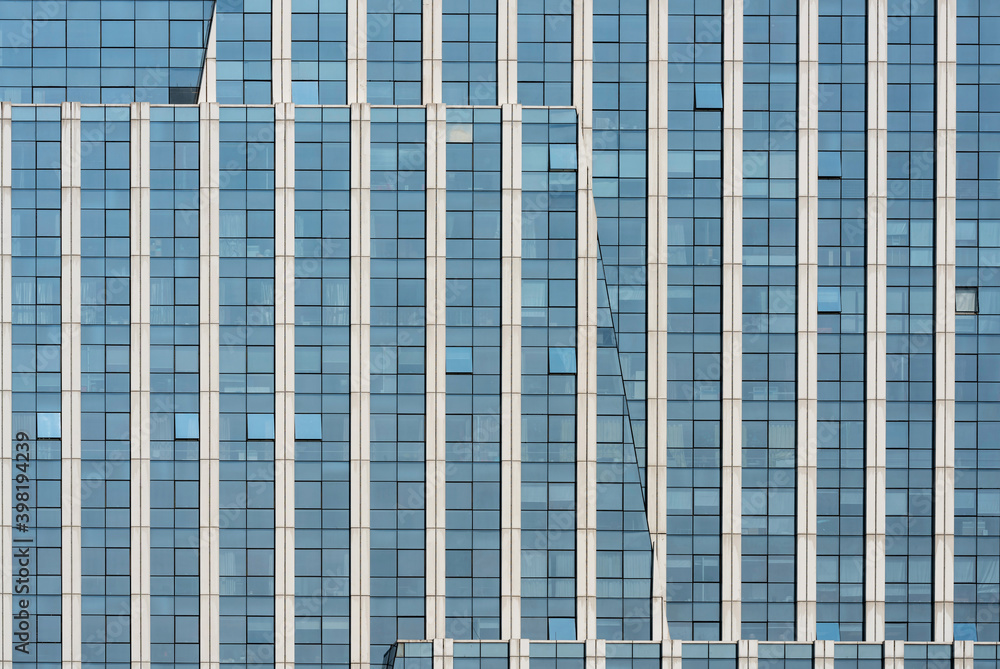 A beautiful background of an glass office building, reflecting clouds in the opened windows