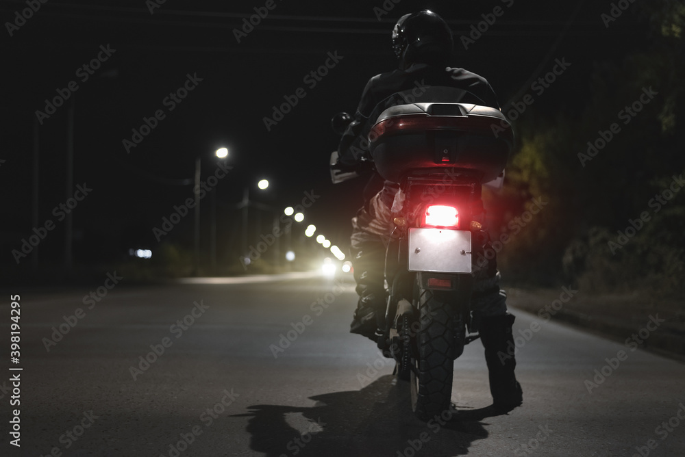 Biker sitting on his motorcycle on a night road.