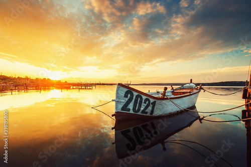 2021 concept Fishing Boat on Varna lake with a reflection in the water at sunset.