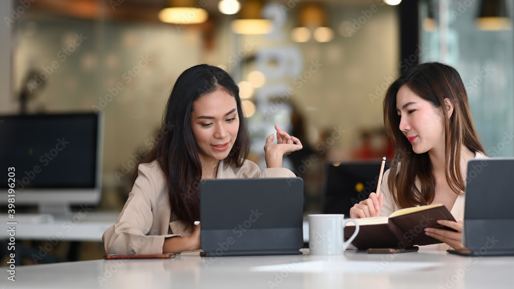 Two businesswoman work together talking and thinking about business improvement in office. Two businesswoman work together talking and thinking about business improvement in office.