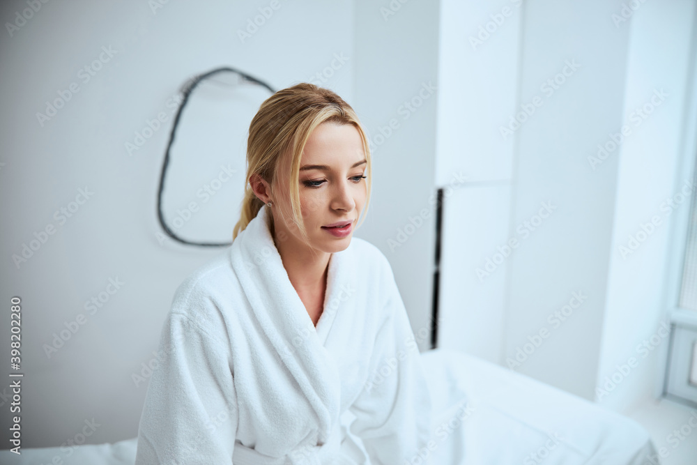 Pensive calm female patient waiting for a cosmetic procedure