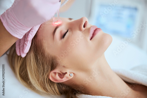 Young patient getting rid of forehead wrinkles photo