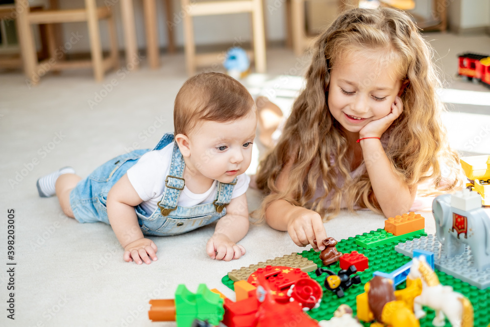 Brother and sister playing together, girl spending time with sibling, teaching him to explore life, cuties Brother and sister playing together, girl spending time with sibling, teaching him to explore life, cuties