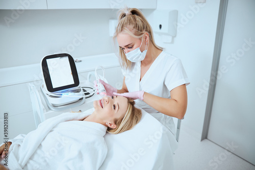 Smiling woman getting a facial skin treatment