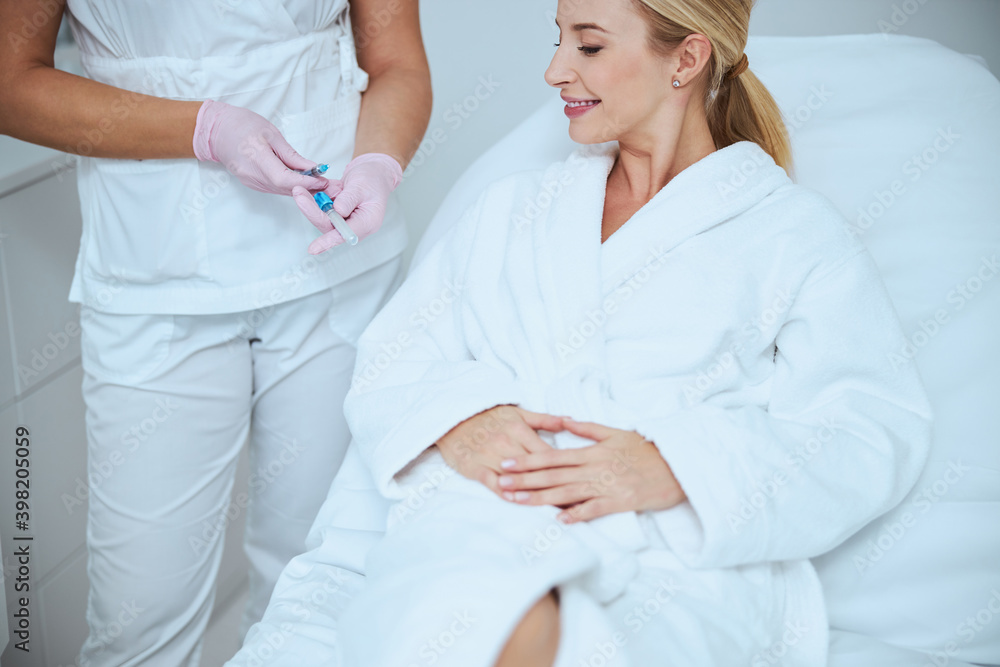 Cosmetologist demonstrating the medical tools before the treatment procedure Cosmetologist demonstrating the medical tools before the treatment procedure